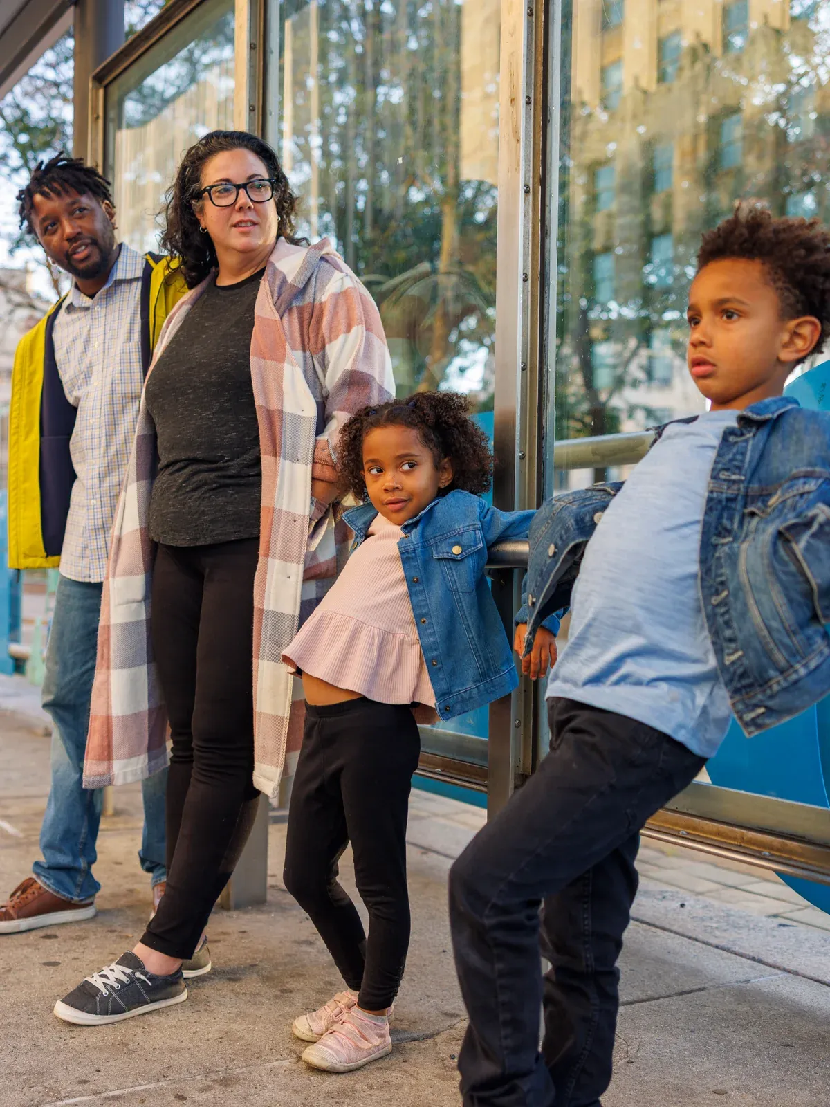 A mother, a father and their two kids wait at a bus shelter in downtown Newark.